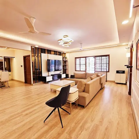 An open living-dining floor with a mirror-clad TV feature wall, a beige sectional sofa around a marble-top coffee table