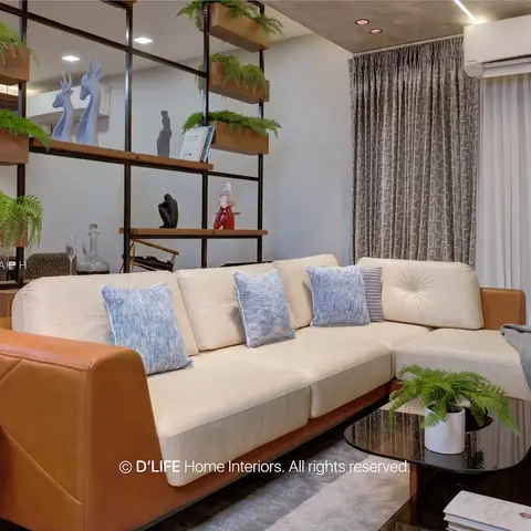An open living space with a tan-and-cream leather sectional sofa facing a black metal etagere planted with ferns
