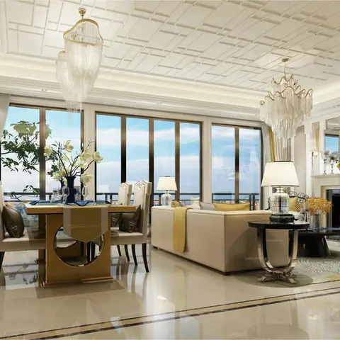 An open-plan dining and living space with twin tiered crystal chandeliers, a marble fireplace mantel, and floor-to-ceiling windows framing a city skyline.