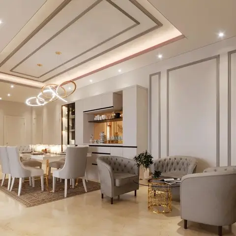 An open-plan space showing a tufted dining set beneath a ring-form gold chandelier and a curved seating lounge with a gold-cage side table
