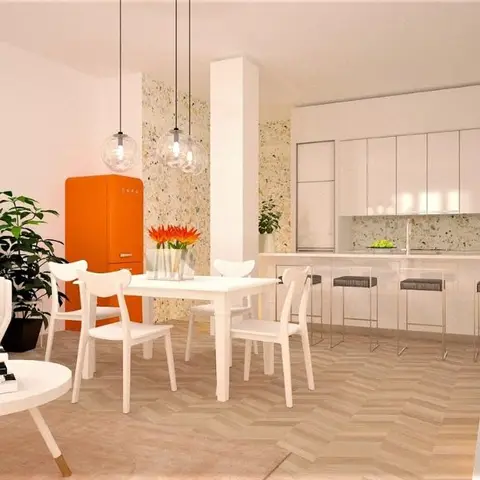 An open-plan space with a white kitchen and terrazzo backsplash beside a dining table, an orange retro fridge, and a white sofa living area