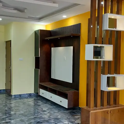 An unfurnished living room with a mustard-yellow accent wall, a dark wood-panel TV unit