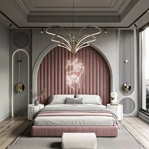 Arched dusty-pink channel-tufted headboard wall carrying a neon line-art hands sign, flanked by grey fluted panels and lit by a splayed gold ring chandelier.