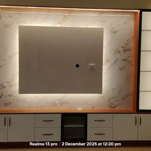 Backlit marble-look TV wall with a timber-lipped recess and a slim five-shelf lit display column, sitting over a low white-and-wenge storage run