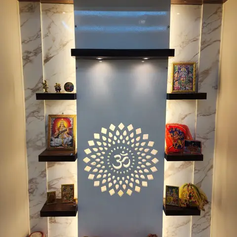 Backlit marble pooja unit with a CNC-cut Om jaali panel flanked by floating shelves of deity frames and idols