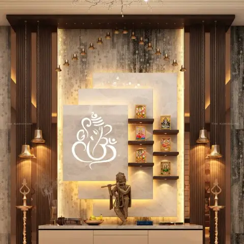 Backlit pooja wall built as three stepped marble panels with an etched Ganesha outline, brass bells hung from a dark wooden pelmet
