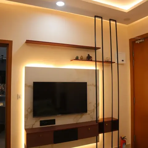 Backlit TV wall with a gold-veined marble panel and a floating rosewood console with brass knobs