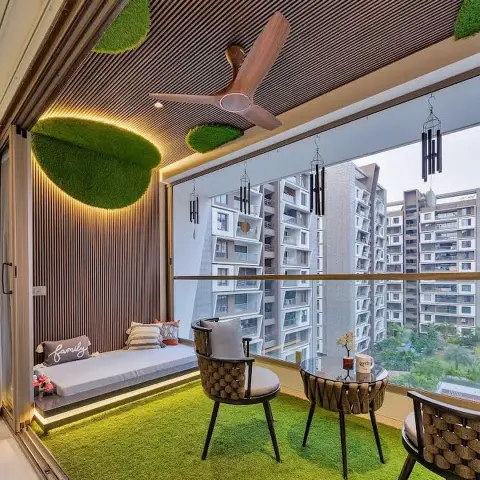 Balcony sit-out with artificial-turf flooring, a wood-slat cove-lit ceiling with moss accents, a built-in daybed bench