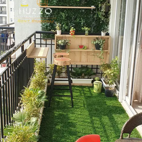 Balcony styled as a green nook with artificial turf, a vertical faux-plant wall, hanging Moroccan lanterns, a wood shelf with potted plants