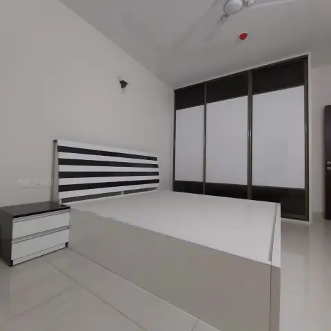 Bare bedroom with a queen bed whose headboard is banded in black-and-white gloss stripes