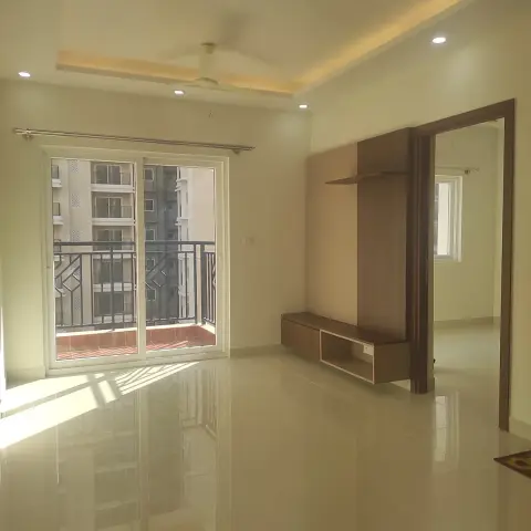 Bare handover-stage apartment hall with a slim laminate TV back-panel and open shelf next to the bedroom door