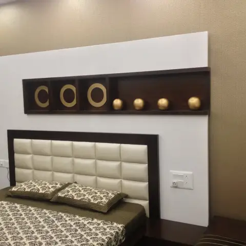 Bed with a square-tufted cream leatherette headboard in a wenge frame set against a white feature panel