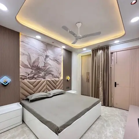 Bed with quilted chevron-pattern headboard panel beneath a botanical leaf mural, box-shaped cove-lit false ceiling with ceiling fan