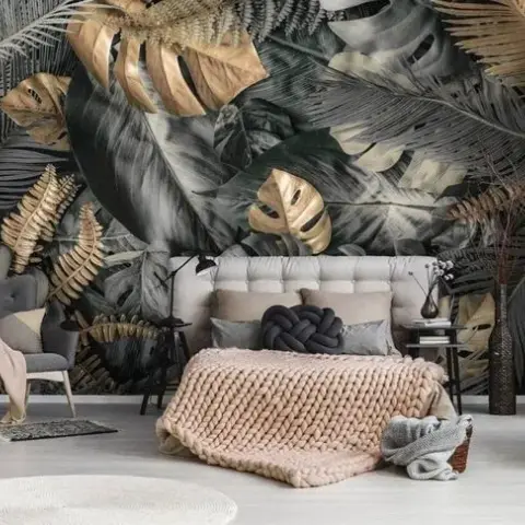 Bedroom against an oversized monstera-and-palm mural in charcoal with gilded gold leaves