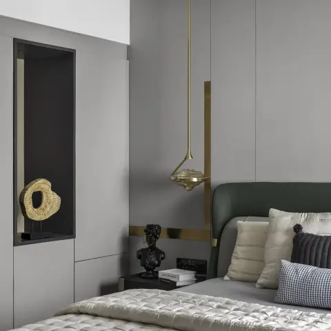 Bedroom corner with a bottle-green leather curved headboard against flush grey panelling inlaid with brass bands