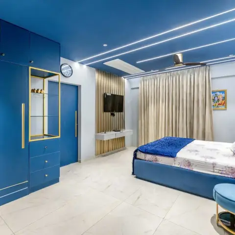 Bedroom done almost entirely in petrol blue - lacquered wardrobe wall with gold inlay grooves and a brass display box