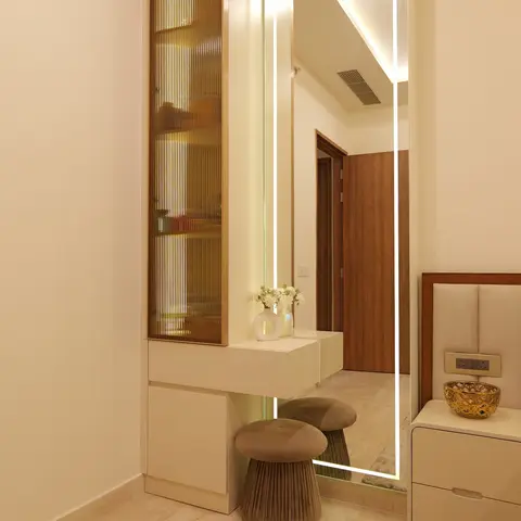 Bedroom dressing nook with a full-length LED-backlit mirror, a fluted amber-glass display cabinet, and two mushroom-shaped velvet stools.