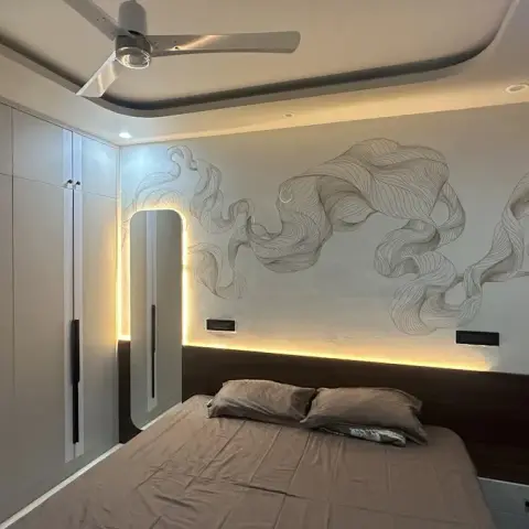 Bedroom lit only by concealed strips: a dark wood headboard ledge with floating side shelves runs the wall under a backlit reveal