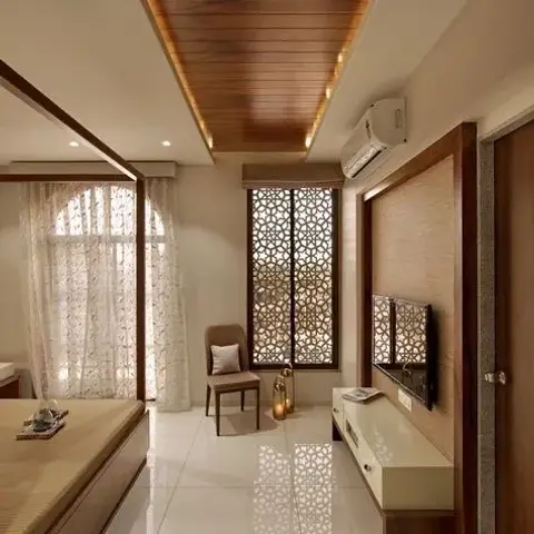 Bedroom looking down a wood-planked ceiling raft edged in cove light to a white CNC jaali screen across the window
