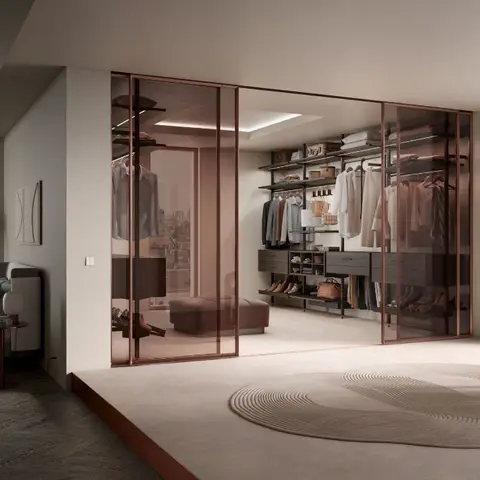 Bedroom opening onto a walk-in wardrobe behind smoked-glass sliding doors, with a round textured rug and a rose-gold floor lamp in the foreground.