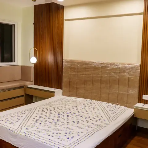 Bedroom photographed at handover with the beige tufted headboard still in its plastic wrap