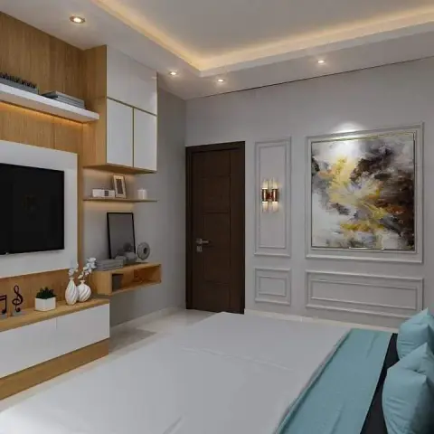 Bedroom seen from the foot of the bed with a teal throw, facing an oak-and-white open-shelf TV wall on one side and a grey moulding-panelled wall carrying a