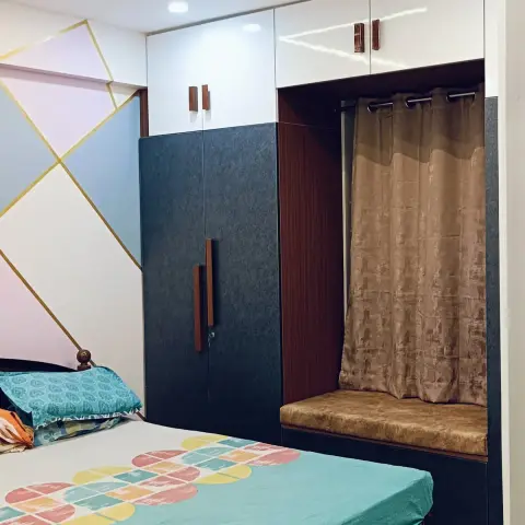Bedroom shot from the doorway: a dark blue textured wardrobe with white gloss lofts and rose-gold handles
