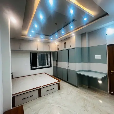 Bedroom under fit-out with a multi-tier POP ceiling with blue accent lighting, a two-tone grey wardrobe wall