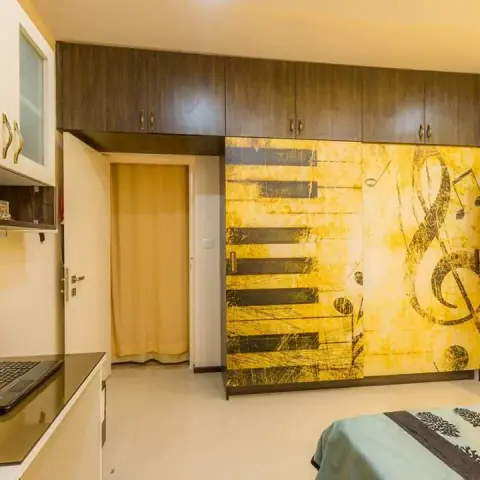 Bedroom wardrobe run whose sliding shutters carry a printed piano-key and treble-clef graphic