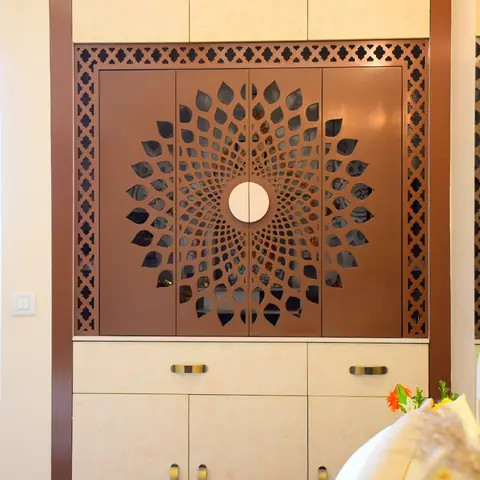 Bedroom wardrobe with a bronze-toned floral laser-cut jaali motif across mirrored central doors