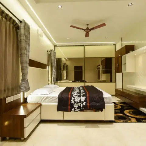Bedroom where a bronze-mirror sliding wardrobe forms the entire headboard wall, with a white-gloss and wenge storage platform bed