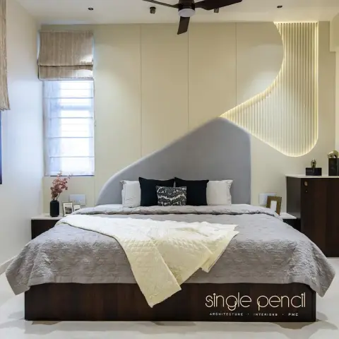 Bedroom where a curved grey velvet headboard sweeps up into a backlit fluted cream panel