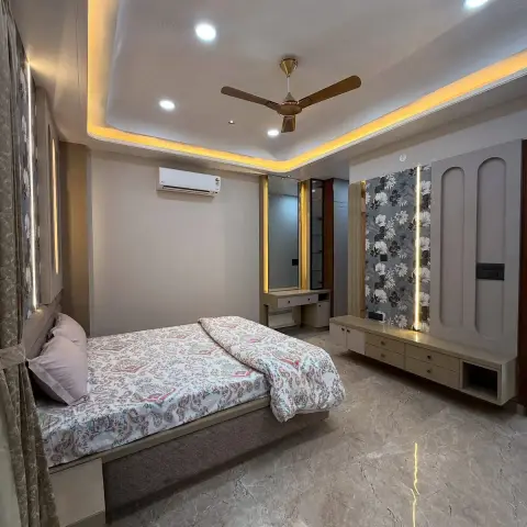 Bedroom where a monochrome floral wallpaper strip is framed by backlit reveals beside routed arch panels, with a floating drawer console under it