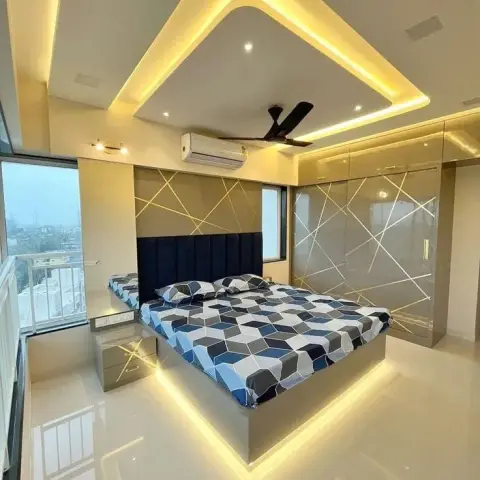 Bedroom where the platform bed floats on an under-base LED glow, a navy fluted headboard sits against a gold criss-cross panel