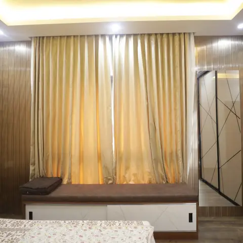 Bedroom with a 3D geometric textured accent wall, gold silk curtains over a window seat, and a crosshatch-pattern glass wardrobe.