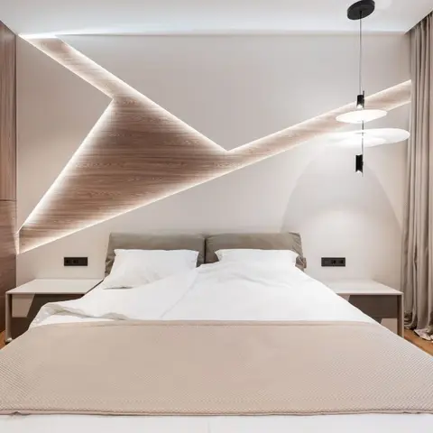 Bedroom with a backlit geometric wood-panel feature wall running from headboard to ceiling, twin globe pendant lights, and a wood-veneer wardrobe wall.