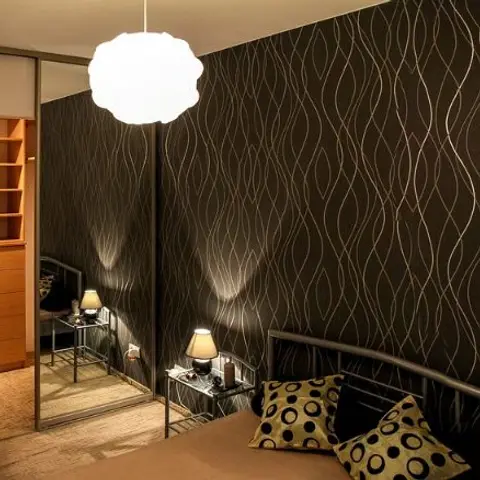 Bedroom with a bold black-and-gold wavy-pattern wallpaper wall, a cloud-shaped pendant lamp over the bed