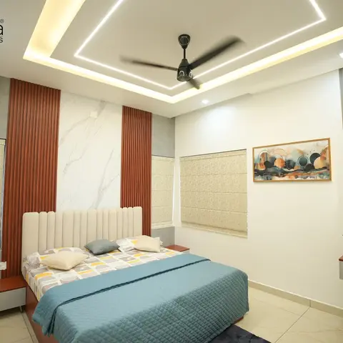 Bedroom with a channel-tufted cream upholstered headboard against a marble panel wall flanked by rust fluted wood panelling, a layered cove-lit false ceiling