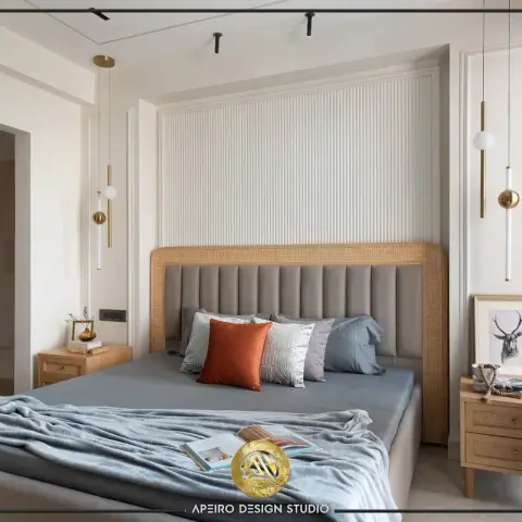 Bedroom with a channel-tufted grey headboard framed in cane, flanked by mixed brass-and-glass pendant lights.