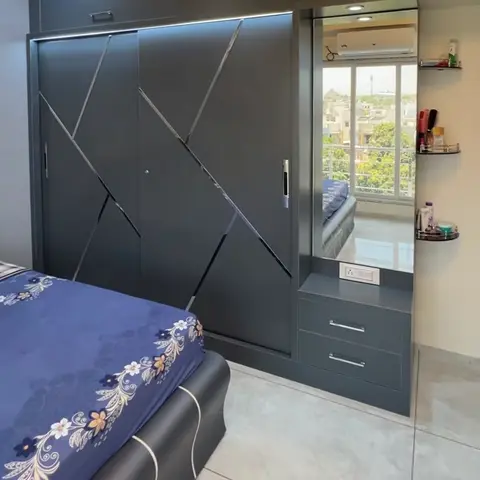 Bedroom with a charcoal sliding wardrobe featuring diagonal chrome inlay, an integrated mirrored dresser with drawers