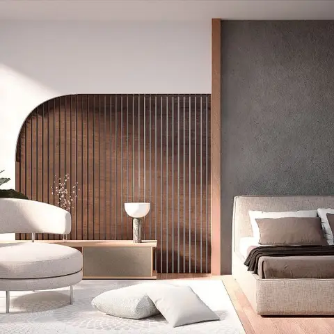 Bedroom with a curved dark-wood fluted-panel screen dividing a cream bouclé lounge chair nook from a bed against a raw charcoal-textured accent wall