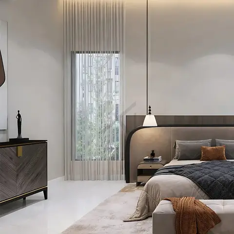 Bedroom with a curved upholstered headboard against a dark wood panel wall, a hanging bedside pendant light, and a sculptural console styled with a figurine.