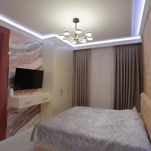Bedroom with a deep-maroon panelled accent wall, a marble-effect panel behind the wall-mounted TV