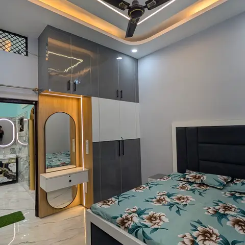 Bedroom with a diamond-shaped cove-lit POP ceiling, a glossy grey-and-white wardrobe, and a backlit arched dressing mirror nook.