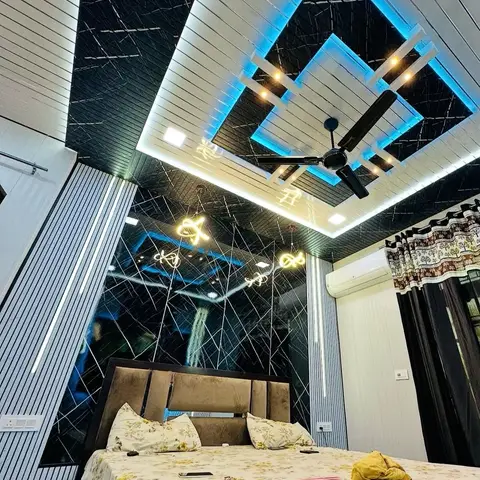 Bedroom with a dramatic multi-tier POP false ceiling in black and white with blue LED trim, a black mirrored feature wall