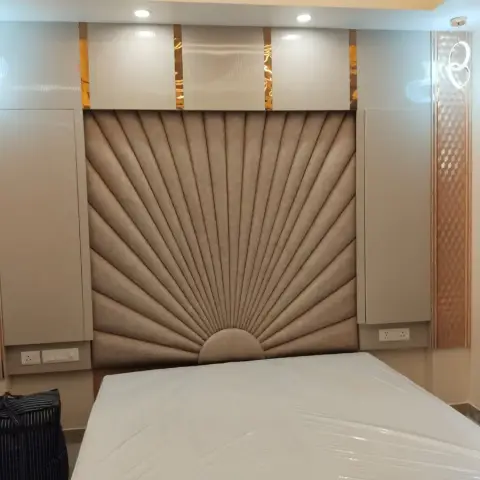 Bedroom with a fan-pleated sunburst upholstered headboard wall flanked by diamond gold-inlay floating cabinets