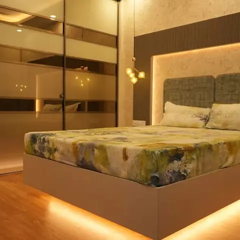 Bedroom with a floating platform bed lit by under-bed cove lighting, a backlit upholstered headboard panel, sliding mirror wardrobe