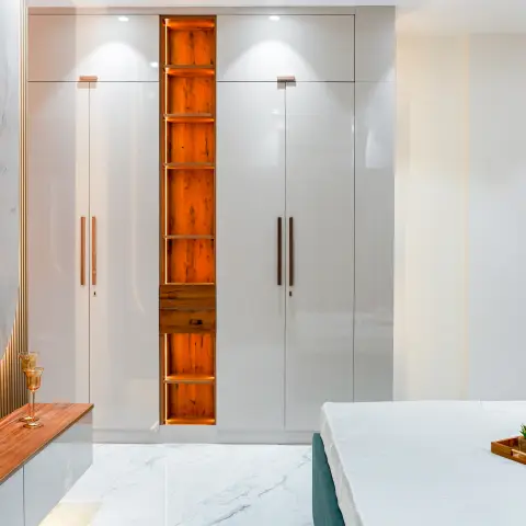 Bedroom with a floor-to-ceiling glossy white wardrobe featuring a backlit wood display niche, wall-mounted TV on book-matched marble