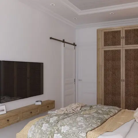 Bedroom with a floor-to-ceiling rattan cane wardrobe wall, a floating wood TV console, and a barn-style closet door.