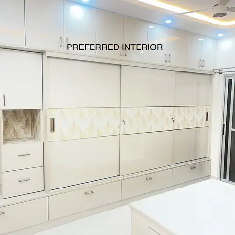 Bedroom with a floor-to-ceiling glossy sliding-door wardrobe featuring a gold leaf-pattern wallpaper inlay strip, cove-lit ceiling